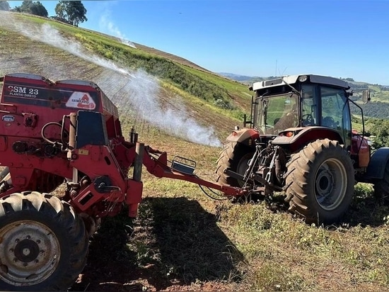 Un agricoltore che lavora sul pendio di un campo